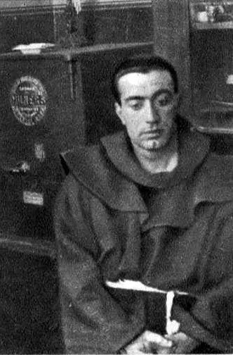 Un homme en habit franciscain, une croix à la main.