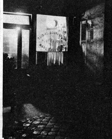 Une entrée d’hôtel dans la nuit parisienne ; son adresse n’est pas précisée.