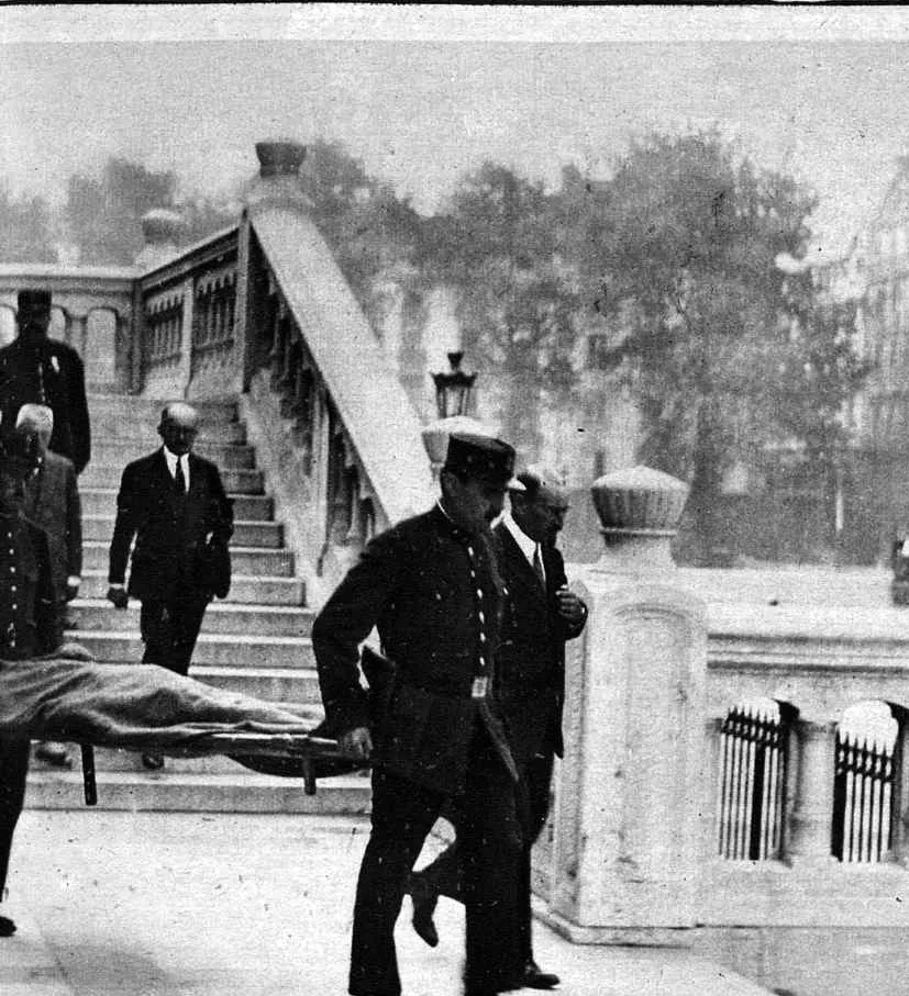 Le corps de Bayle, couvert sur une civière, est emporté du Palais de justice.